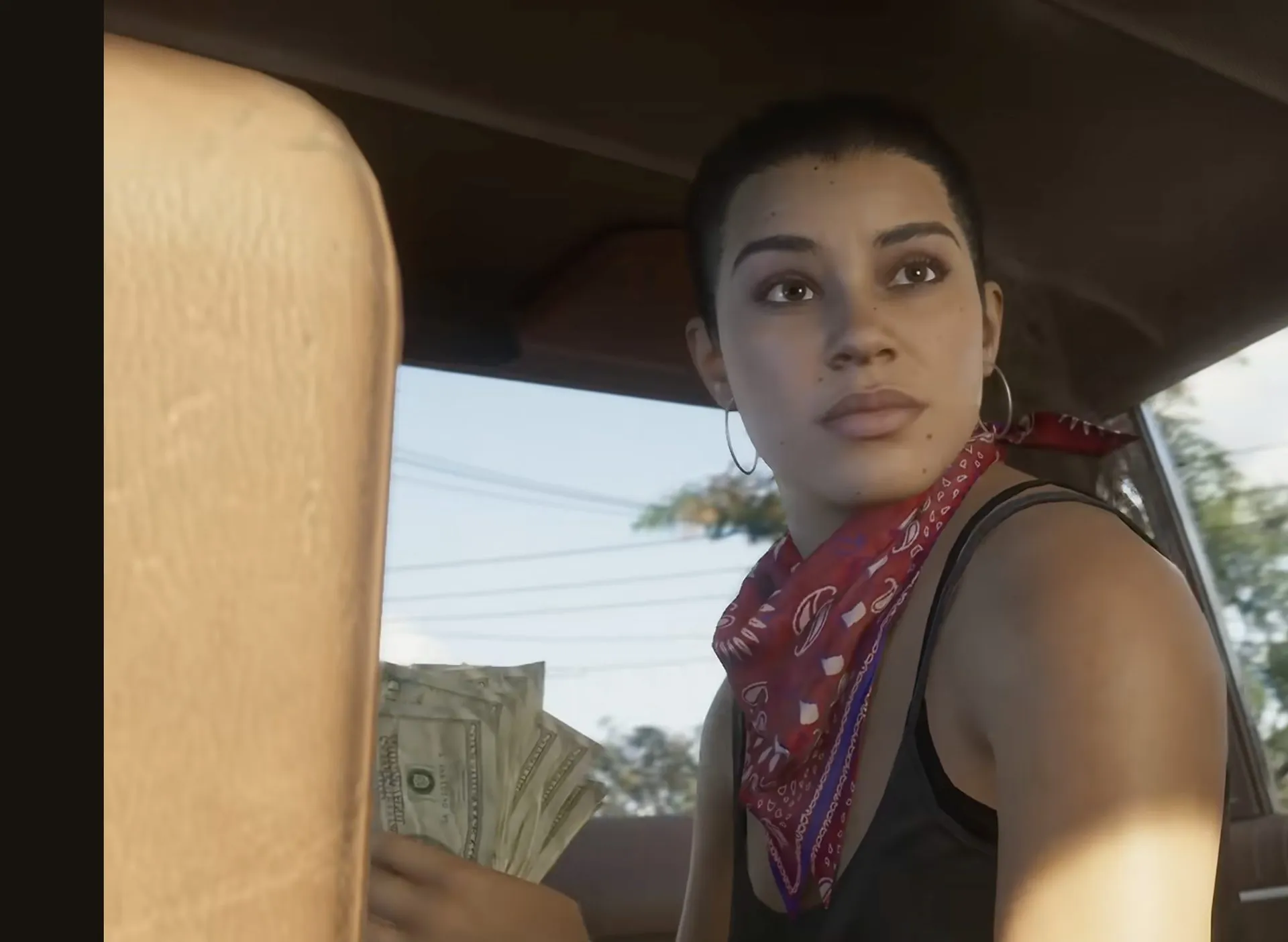 A fan of banknotes held inside a car
