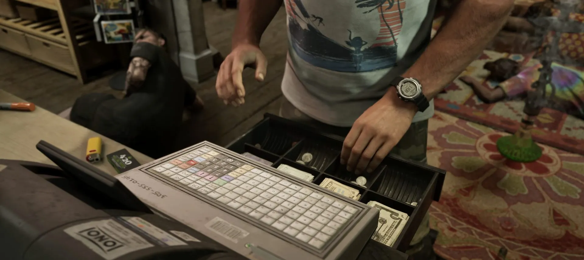 An open cash register drawer full of bills, a hand above it
